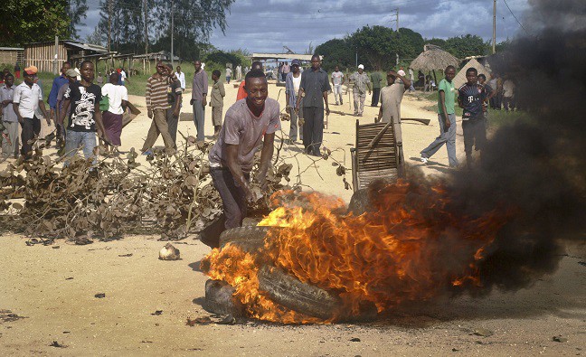 Residents barricade a road with burning tires as they protest against the government’s failure to intervene in recent killings. CREDIT: AP
