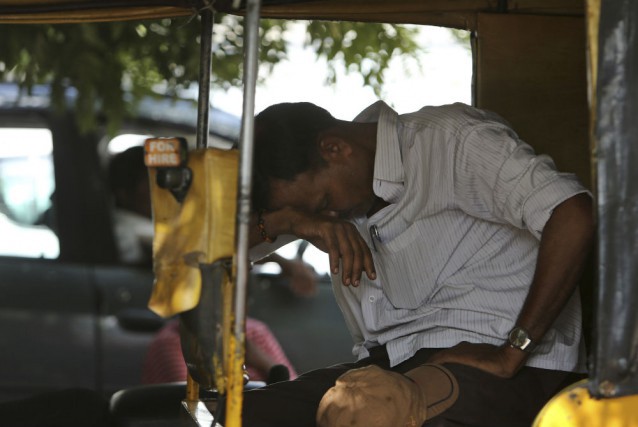 An Indian auto rickshaw driver rests on a hot summer day in Hyderabad, India, Monday, May 25, 2015. CREDIT: AP Photo/Mahesh Kumar A.