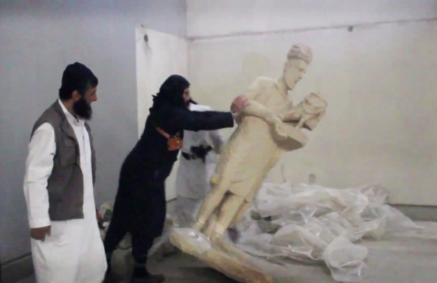 In this image made from video posted on a social media account affiliated with the Islamic State group on Thursday, Feb. 26, 2015, which has been verified and is consistent with other AP reporting, a militant topples an ancient artifact in the Ninevah Museum in Mosul, Iraq. CREDIT: AP