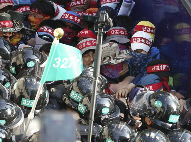 Members of the Korean Confederation of Trade Unions struggle with riot policemen as they march toward the presidential house after a May Day rally in Seoul, South Korea, Friday, May 1, 2015. CREDIT: AP