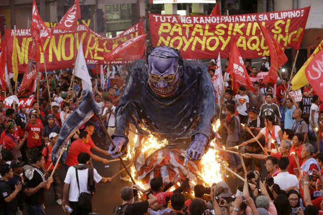 Protesters, mostly workers, set on fire to an effigy of Philippine President Benigno Aquino III during a rally near the Presidential Palace in Manila to mark May Day Friday, May 1, 2015, a national holiday in the Philippines. Thousands of workers converged near the palace to call for the resignation of Aquino, demand higher wages, better working conditions, fair export labor policies and a halt to contractualization. CREDIT: AP