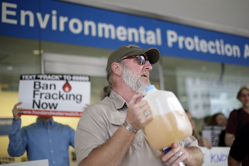 Ray Kemble of Dimock, Pa., displays a jug of what he identifies as his contaminated well water as he speaks at a demonstration opposed to hydraulic fracturing. CREDIT: AP PHOTO/MATT ROURKE