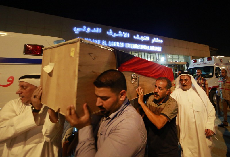 In this Saturday, June 27, 2015 photo, a coffin draped with a Kuwaiti flag belonging to a victim of a suicide bombing that targeted a Shiite mosque in Kuwait on Friday, arrives to Najaf Airport, for the funeral procession, in the Shiite holy city of Najaf, Iraq. Kuwaiti authorities on Sunday identified the suicide bomber behind an attack on a Shiite mosque that killed more than two dozens as a Saudi citizen who flew into the Gulf nation just hours before he blew himself up. CREDIT: AP
