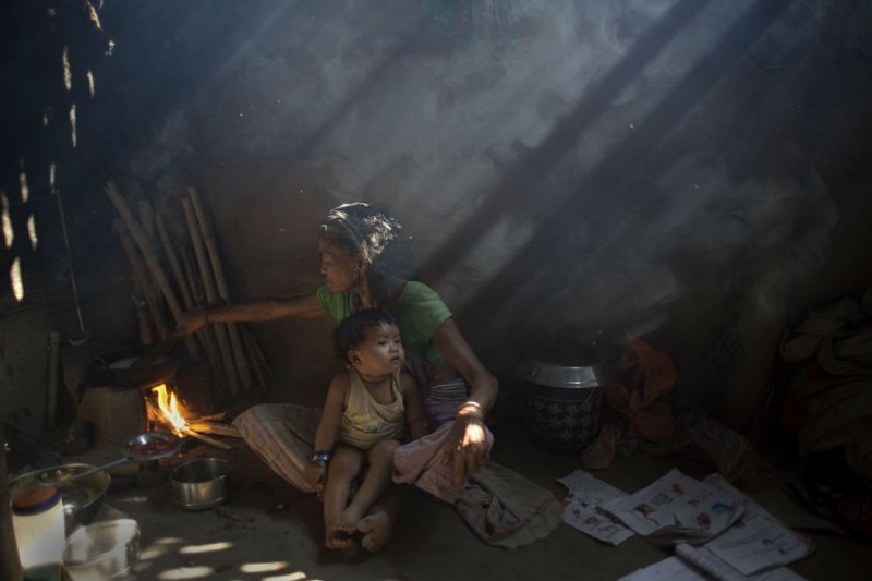 In this Tuesday, March 31, 2015 photo, an elderly Indian woman cooks using firewood at her home at Gobhali village on the outskirts of Gauhati, India. CREDIT: AP Photo/ Anupam Nath