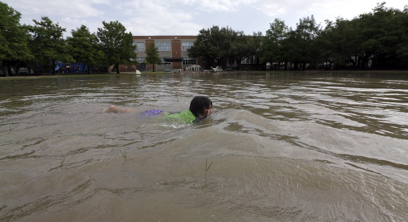 Joselyn Ramirez swims in a flooded school playground in Houston, Tuesday, May 26, 2015. Severe weather in the Houston area overnight caused flooding. CREDIT: AP PHOTO/DAVID J. PHILLIP
