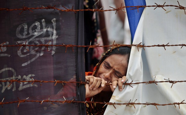 A Bangladeshi woman cries at the site of the Rana Plaza building collapse 100 days after the tragedy. CREDIT: AP