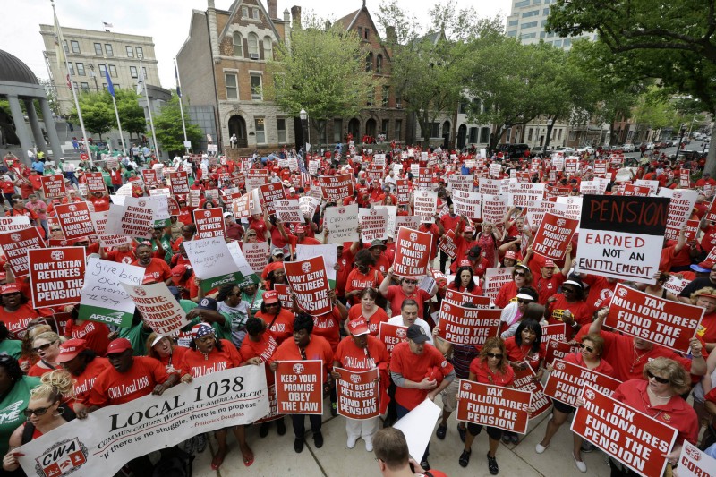 A large crowd of mostly public employee union members fill the plaza and street in front of the Statehouse Tuesday, May 12, 2015, in Trenton, N.J. The unions are protesting of Gov. Chris Christie’s pension funding reductions. CREDIT: AP PHOTO/MEL EVANS