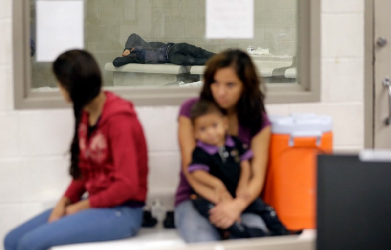 Women and children wait at a U.S. Customs and Border Protection processing facility, in Brownsville, Texas. CREDIT: ERIC GAY/ AP