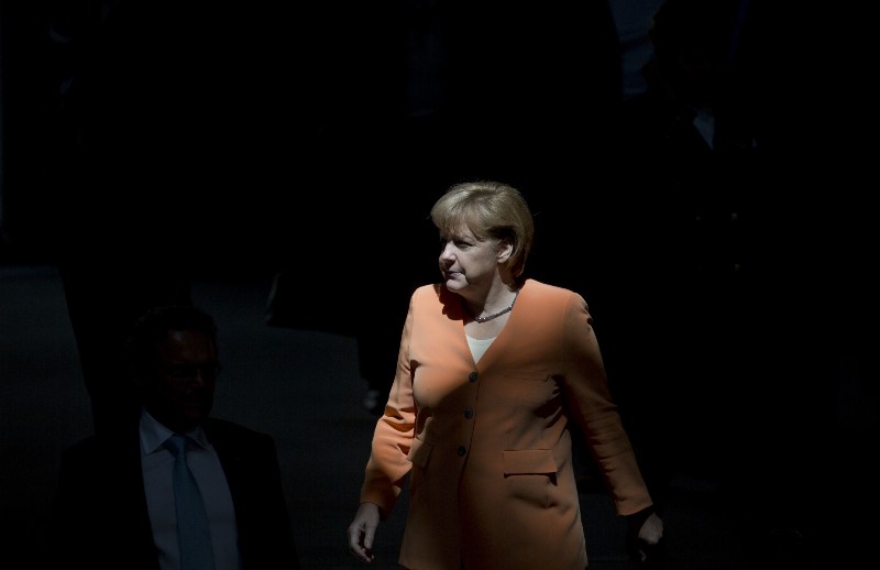 German Chancellor Angela Merkel walks through a beam of sunlight as she arrives for a special session of the Germany Parliament Bundestag in Berlin, Germany, Thursday, July 19, 2012. CREDIT: AP