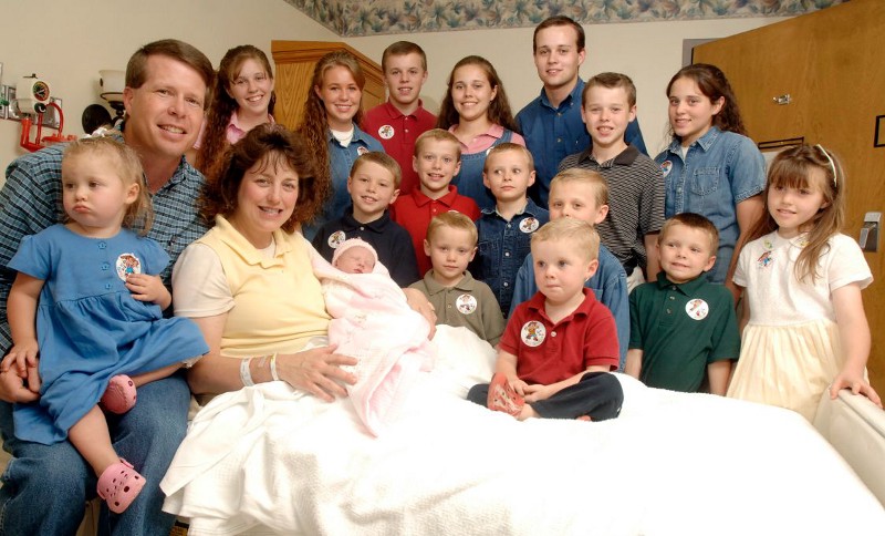 In this Aug. 2, 2007 file photo, Michelle Duggar, left, is surrounded by her children and husband Jim Bob, second from left, after the birth of her 17th child in Rogers, Ark. CREDIT: AP/ BETH HALL