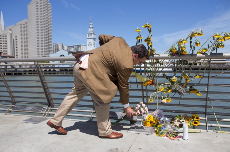 A mourner lays down flowers following a vigil for Kathryn Steinle, Monday, July 6, 2015, on Pier 14 in San Francisco. Steinle was gunned down while out for an evening stroll at Pier 14 with her father and a family friend on Wednesday, July 1. CREDIT: AP PHOTO/BECK DIEFENBACH