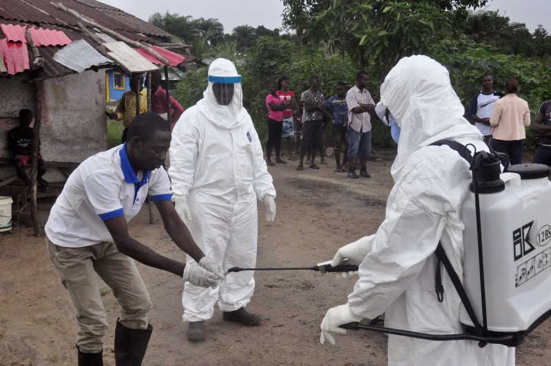 Health workers wash their hands after taking a blood specimen from a child to test for the Ebola virus in an area where a 17-year old boy died from the virus on the outskirts of Monrovia, Liberia, Tuesday, June 30, 2015. Liberian authorities on Tuesday quarantined the area where the corpse of the boy was found, sparking fears this West African country could face another outbreak of the disease nearly two months after being declared Ebola-free. CREDIT: AP PHOTO/ ABBAS DULLEH