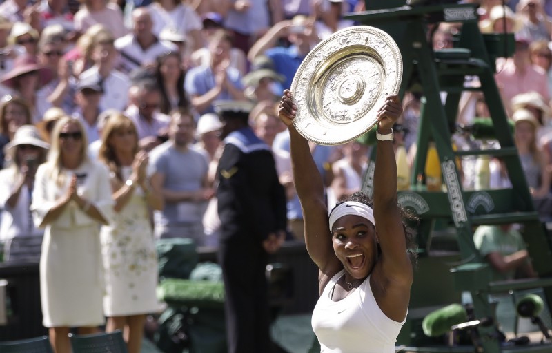 Serena Williams holds up the trophy after winning the women’s singles final in Wimbledon CREDIT: AP PHOTO/PAVEL GOLOVKIN