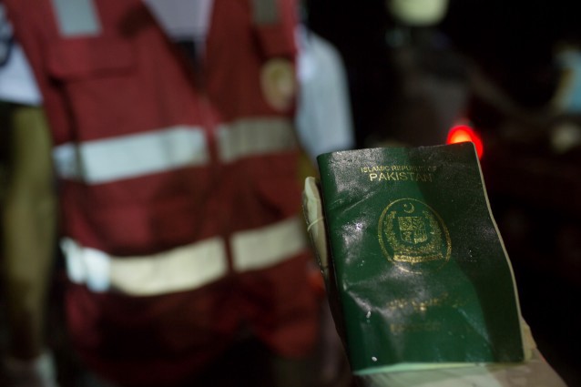 A rescuer holds a waterlogged Pakistani passport as they collect bodies of migrants who drowned off the coast of Zuwara, Libya. CREDIT: AP Photo/Mohamed Ben Khalifa