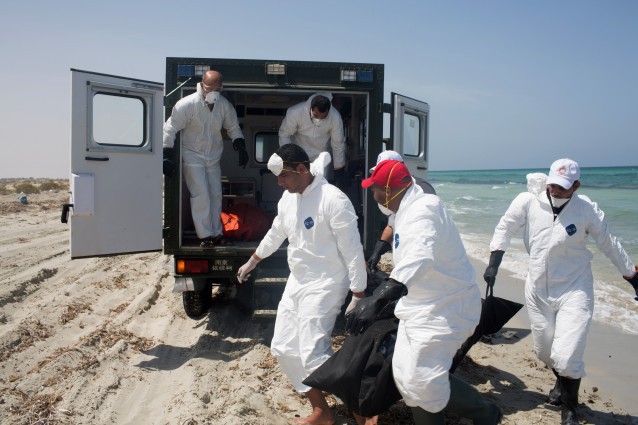 Workers for the Red Crescent carry the body of a dead migrant, in a black body bag, to a nearby truck. CREDIT: AP Photo/Mohamed Ben Khalifa