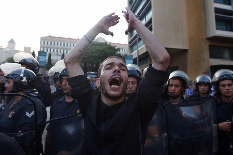 A Lebanese man chants slogans in front of Lebanese riot police, during a protest against the ongoing trash crisis, in downtown Beirut, Lebanon, Wednesday, Aug. 19, 2015. Lebanon’s health minister says the country is on the brink of a “major health disaster” unless an immediate solution is found for its mounting trash problem. Garbage has been collecting on the streets in Lebanon for the past month amid government paralysis and inability to agree on a solution after Beirut’s main landfill was closed down. (AP Photo/Bilal Hussein) CREDIT: AP Photo/Bilal Hussein