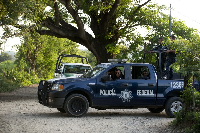 In this Aug. 26, 2014 photo, federal police and immigration vehicles patrol near the railroad tracks as a northbound freight train departs from Arriaga, Mexico. A Mexican crackdown seems to be keeping women and children off the deadly train, known as “The Beast,” that has traditionally helped thousands of migrants head north. CREDIT: AP PHOTO/REBECCA BLACKWELL