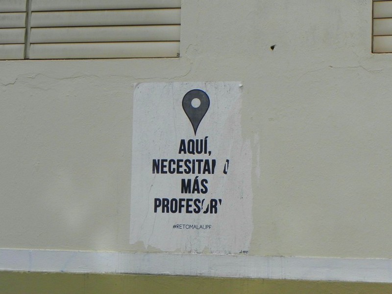A poster at the University of Puerto Rico in San Juan reads, “Here we need more professors. Take back the UPR!” CREDIT: Alice Ollstein