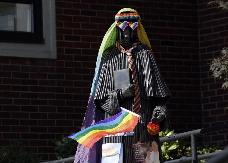 A statue outside St. Mary’s Academy is adorned with rainbow colored symbols as part of a student protest. CREDIT: AP PHOTO/DON RYAN, FILE