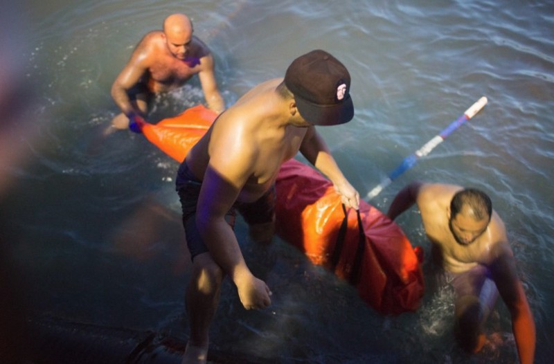 Rescuers remove the body of a migrant after their boat sank off the coast of in Zuwara, Libya CREDIT: AP Photo/Mohamed Ben Khalifa