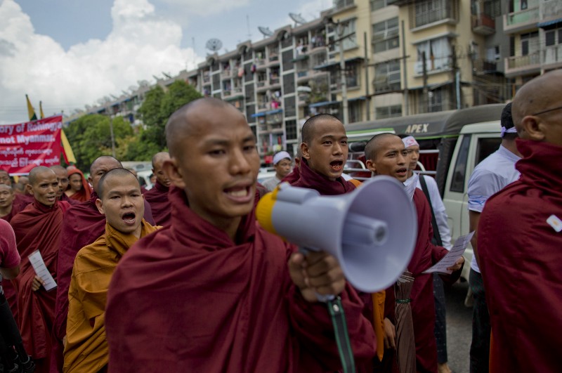 Myanmar’s nationalist Buddhist monks shout slogans during a protest rally in Yangon, Myanmar, Wednesday, May 27, 2015. About 300 protesters, led by radical Buddhist monks, rallied claiming boat people washing onto Southeast Asian shores were not Rohingya Muslims, a religious minority the government and many others in the predominantly Buddhist nation say do not exist. CREDIT: AP/GEMUNU AMARASINGHE