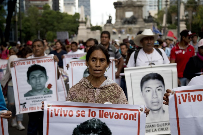 Relatives and protestors carry banners with pictures of some of the 43 missing students from a rural teachers college, during a march in Mexico City, Wednesday, Aug. 26, 2015. CREDIT: AP PHOTO/EDUARDO VERDUGO
