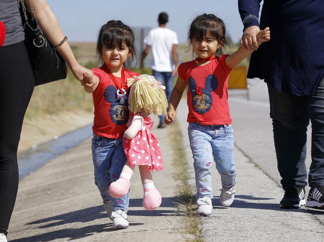 Migrants including these two girls trying to reach Europe walk outside the Turkish city of Edirne, which borders European Union members Greece and Bulgaria, Wednesday, Sept. 16, 2015. CREDIT: AP Photo/Emrah Gurel