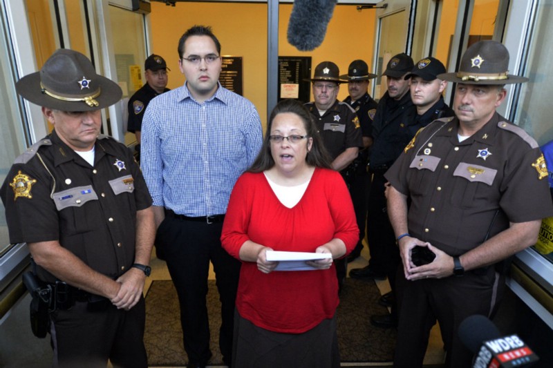 Kim Davis, flanked by her son Nathan Davis, one of her deputies, and Rowan County Sheriff’s deputies. CREDIT: AP PHOTO/TIMOTHY D. EASLEY