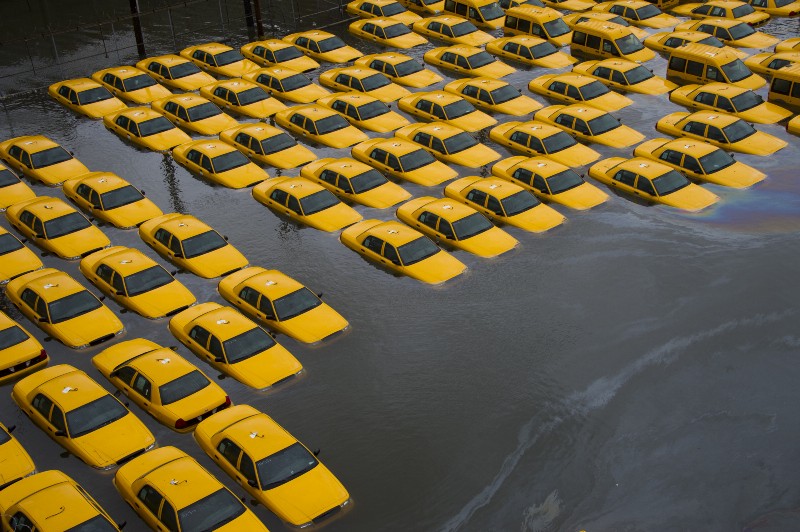 In this Oct. 30, 2012 file photo, a parking lot full of yellow cabs in Hoboken, N.J. is flooded as a result of Superstorm Sandy. CREDIT: AP PHOTO/CHARLES SYKES
