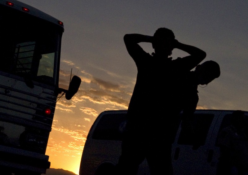 An undocumented immigrant from El Salvador is searched on the tarmac prior to boarding an MD-80 aircraft for a repatriation flight of 80 immigrants to their home country, Tuesday, June 26, 2012 at Phoenix-Mesa Gateway Airport in Mesa, Ariz. CREDIT: AP PHOTO/MATT YORK