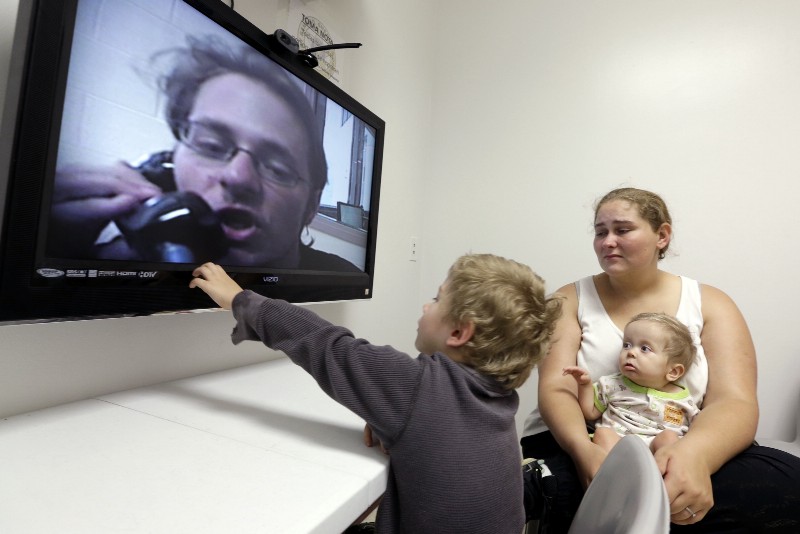 A family in a video visitation at the Fort Bend County Jail in Texas CREDIT: AP PHOTO/DAVID J. PHILLIP