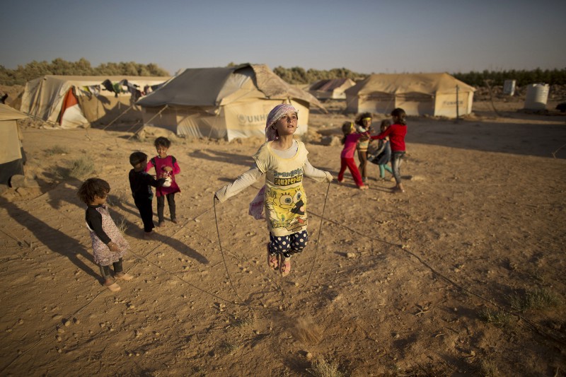 n this Sunday, July 19, 2015 file photo, Syrian refugee girl, Zubaida Faisal, 10, skips a rope while she and other children play near their tents at an informal tented settlement near the Syrian border on the outskirts of Mafraq, Jordan. CREDIT: AP PHOTO/MUHAMMED MUHEISEN