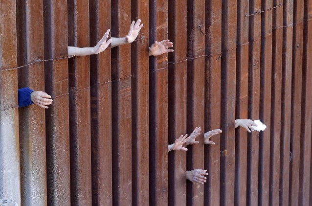 People on the Mexican side of the international border worship while Cardinal Sean O’Malley leads mass, Tuesday, April 1, 2014, in Nogales, Ariz. CREDIT: AP Photo/Matt York