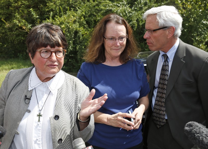 Kathleen Lord, center, and Don Knight, right, two of Richard Glossip’s defense attorneys, talk as Sister Helen Prejean, left, addresses the media outside the Oklahoma State Penitentiary. CREDIT: AP PHOTO/SUE OGROCKI