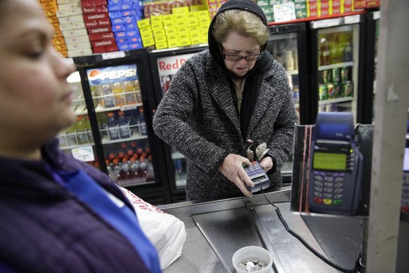 A New Jersey woman pays for groceries with food stamps CREDIT: AP PHOTO/SETH WENIG