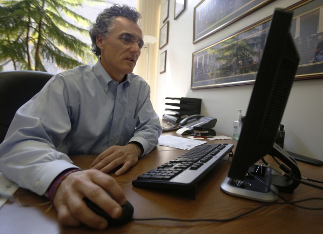 Tom Dart, sheriff of Cook County, looks at computer screen in an office at his Chicago headquarters CREDIT: AP Photo/Martha Irvine