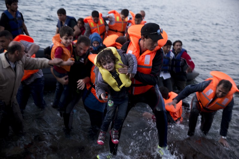 Syrian refugees arrive aboard a dinghy after crossing from Turkey, to the island of Lesbos, Greece, on Sunday, Sept. 20, 2015. CREDIT: AP PHOTO/PETROS GIANNAKOURIS