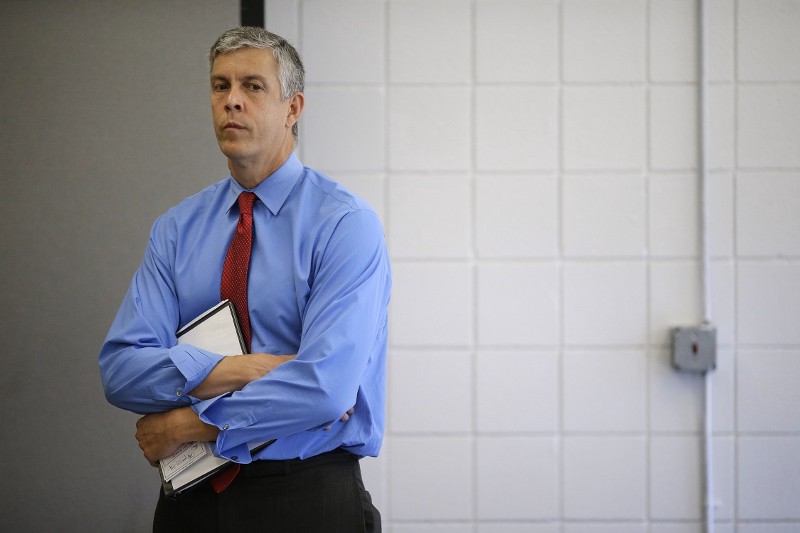 Arne Duncan stands to the side of a news conference. CREDIT: AP PHOTO/PATRICK SEMANSKY