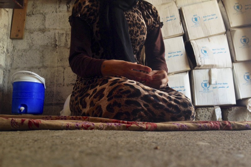 A 15-year-old Yazidi girl captured by the Islamic State group and forcibly married to a militant in Syria sits on the floor of a one-room house she now shares with her family after escaping in early August. CREDIT: AP PHOTO/DALTON BENNETT