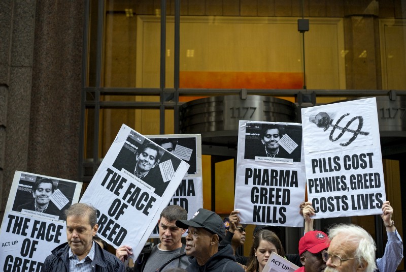 Activists hold signs containing the image of Turing Pharmaceuticals CEO Martin Shkreli on Oct. 1, 2015, during a protest highlighting pharmaceutical drug pricing. CREDIT: AP PHOTO/CRAIG RUTTLE
