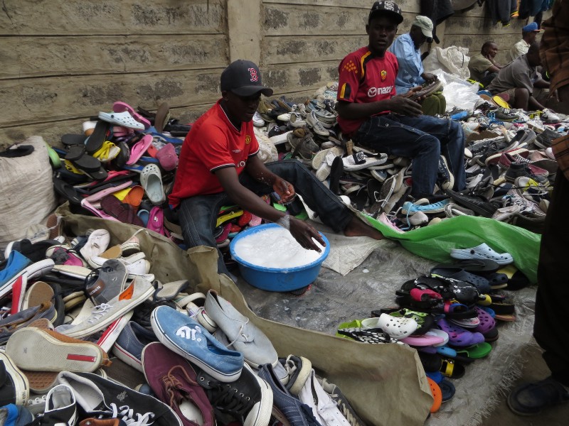 Shopkeeper’s in Nairobi’s Gikomba market wash secondhand shoes to sell. CREDIT: BEENISH AHMED