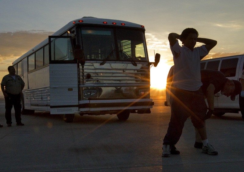 An undocumented immigrant from El Salvador is searched on the tarmac at Phoenix-Mesa Gateway Airport as the sun rises prior to boarding an MD-80 aircraft for a repatriation flight of 80 immigrants to their home country, Tuesday, June 26, 2012 in Mesa, Ariz. Immigration and Customs Enforcement (ICE) operate four to five repatriation flights weekly to El Salvador, Guatemala and Nicaragua. Shackled violent offenders, minors and women are separated on the flight and are turned over to El Salvador’s immigration officers upon arrival. (AP Photo/Matt York) CREDIT: AP PHOTO/MATT YORK
