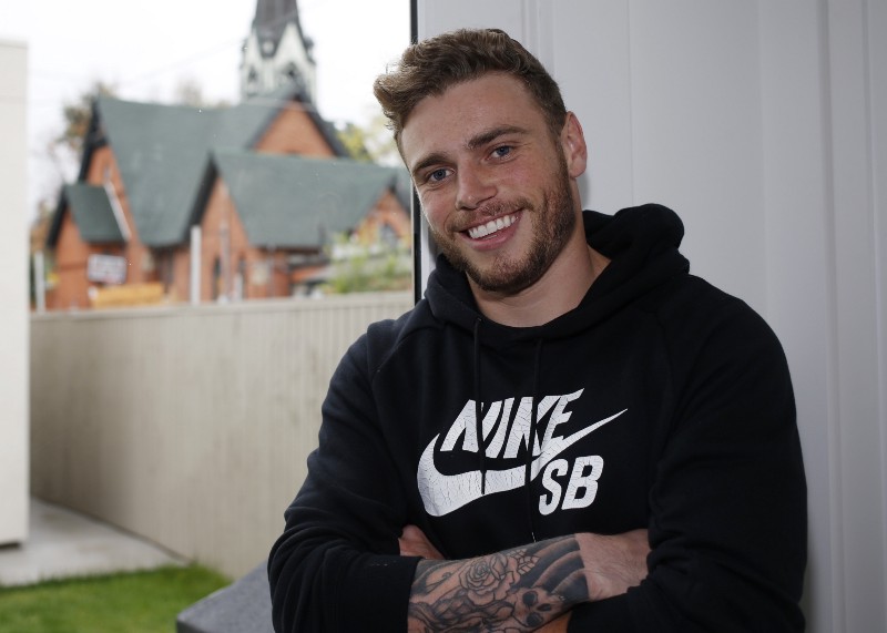 In this Wednesday, Oct. 21, 2015, photo, Gus Kenworthy, a freestyle skier who won a silver medal in Sochi, poses in his home in Denver. The timing, to say nothing of the country, wasn’t quite right to tell the world he was gay. And so Kenworthy left Russia last February better known as the compassionate daredevil who adopted several stray dogs he came across in the mountains _ and as the man who was part of an historic U.S. sweep of the first Olympic ski slopestyle contest. (AP Photo/David Zalubowski) CREDIT: DAVID ZALUBOWSKI, AP