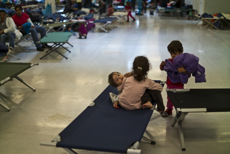 A Syrian refugee child is held by his sister while playing on a stretcher at a refugee shelter in Freilassing, Germany, Thursday, Sept. 24, 2015. CREDIT: AP PHOTO/MUHAMMED MUHEISEN