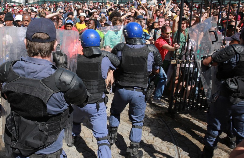 Protesting university students clash with riot police outside Parliament in Cape Town, South Africa, Wednesday Oct. 21, 2015. CREDIT: AP PHOTO/NARDUS ENGELBRECHT