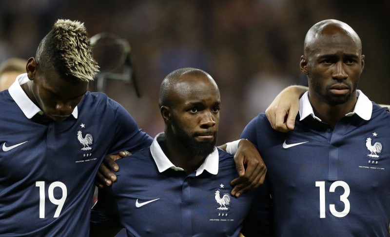 France’s Paul Pogba, Lassana Diarra, whose cousin was killed in the Paris attacks, and Eliaquim Mangala, from left, during a rendition of the French national anthem before the international friendly soccer match between England and France at Wembley Stadium in London.