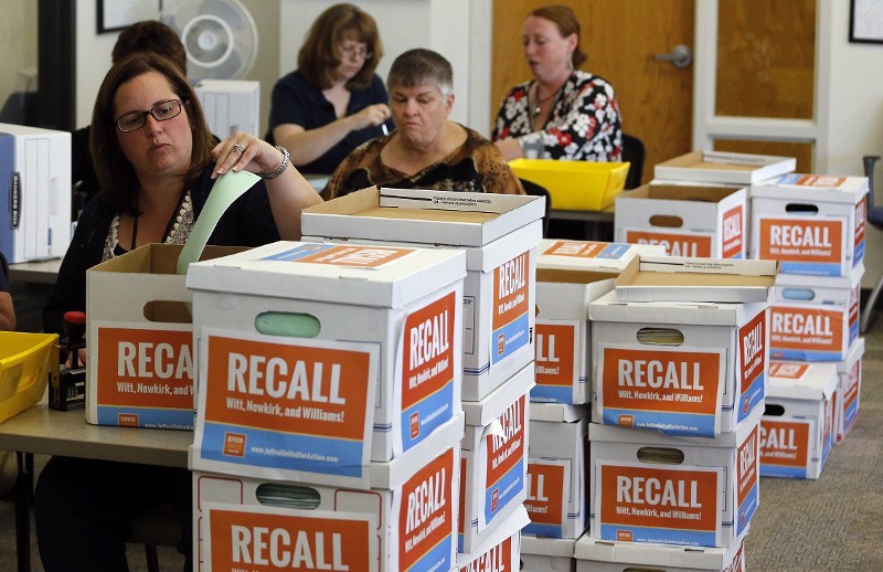 Jefferson County election workers count and stamp petitions collected by a group of parents and educators, called Jeffco United for Action, whose aim is to remove Jefferson County School Board members. CREDIT: BRENNAN LINSLEY, AP