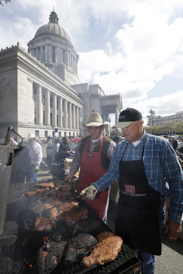 Jack Field, left, executive vice president of the Washington Cattlemen’s Association, and Don Blakemore, who works for the animal pharmaceutical company Merial, celebrate “Beef Day” Capitol dome in Olympia, Wash. CREDIT: AP Photo/Ted S. Warren