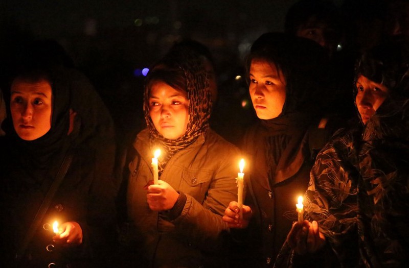 Hazara women hold candles during a ceremony for beheaded Hazara victims, in Kabul, Afghanistan, Tuesday, Nov. 10, 2015. The beheaded bodies of seven Hazaras were found in Zabul, neighboring Ghazni, on Saturday. CREDIT: AP Photos/Massoud Hossaini