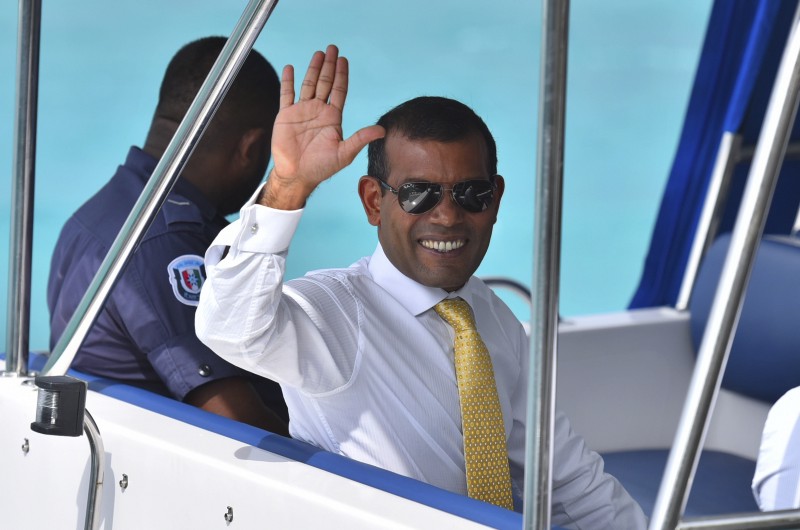 Maldives former President Mohamed Nasheed waves sitting in a boat as he is taken back to Dhoonidhoo prison after a court dismissed his appeal against his arrest in Male, Maldives, Sunday, March 15, 2015. CREDIT: AP PHOTO/ MOHAMED SHARUHAAN